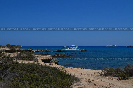 Морской берег с яхтой вдали. Крит. Остров Иерапетра. (2018 год). Стоковое фото, фотограф Юлия Кваскова / Фотобанк Лори