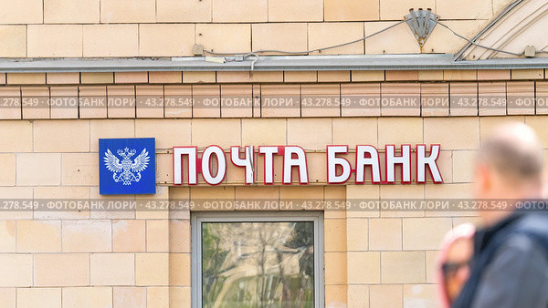 Moscow May 05 2024. Pochta Bank. Sign on building, passers-by walking by blurred in foreground. Редакционное фото, фотограф Скрипачев Антон / Фотобанк Лори