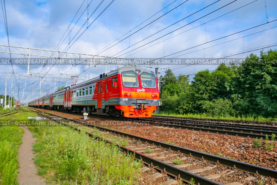 Moscow region, Russia, July 2018: Passenger electric train of the Russian Railways ED4M moves against a background of green forest (editorial) Стоковое фото, фотограф Михаил Строгалев / Фотобанк Лори
