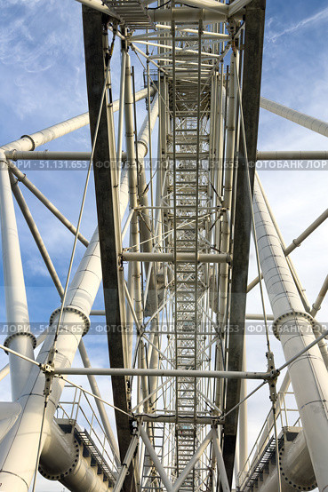 Moscow, Russia - 05.26.2025: View on capsule cabin with people against giant steel frame structure of a ferris wheel Sun of Moscow. Modern ferris wheel in VDNKh park, Moscow, Russia. Редакционное фото, фотограф Ирина Михайличенко / Фотобанк Лори