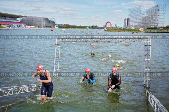 MOSCOW, RUSSIA - AUG 14, 2016: Participants of swimming stage of traditional 3Grom series triathlon contest in Krylatskoye Rowing Channel. Редакционное фото, фотограф Losevsky Pavel / Фотобанк Лори