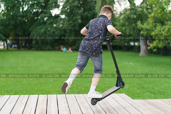 Moscow, Russia - July 26-2019 Trick at sportive push scooter in the park. Редакционное фото, фотограф YuryKara / Фотобанк Лори