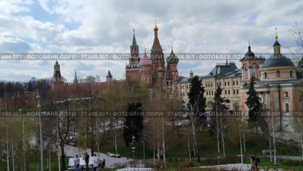 Москва, Россия - 28 апреля 2022: Вид на Московский Кремль и Храм Василия Блаженного из парка Зарядье. Люди гуляют по весеннему городскому парку. Редакционное видео, видеограф Ирина / Фотобанк Лори