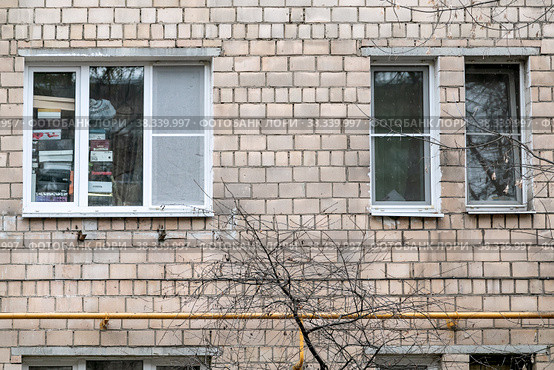 Москва, СВАО, микрорайон Марфино, улица Академика Комарова, 12. Окна на фасаде старого кирпичного дома: два узких и одно широкое. Широкое окно  заваленное коробками (2022 год). Редакционное фото, фотограф Наталья Николаева / Фотобанк Лори