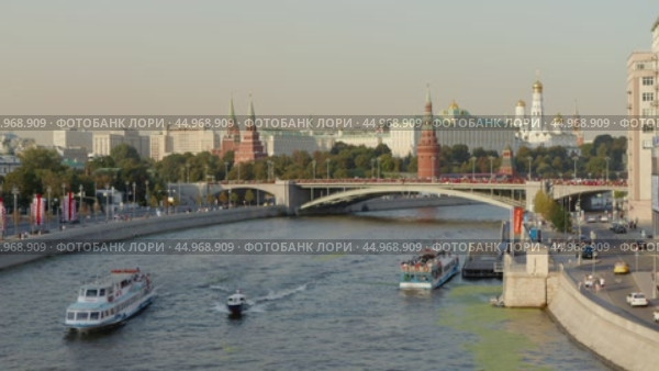 Москва. Вид с Патриаршего моста на Кремль и Большой Каменный мост. По Москве-реке проплывают речные прогулочные теплоходы. Теплое вечернее солнечное освещение. Лето. Редакционное видео, видеограф Сергей Никифоров-Гордеев / Фотобанк Лори
