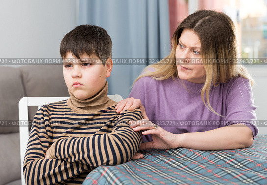 Mother and offended son arguing in domestic interior. Стоковое фото, фотограф Яков Филимонов / Фотобанк Лори