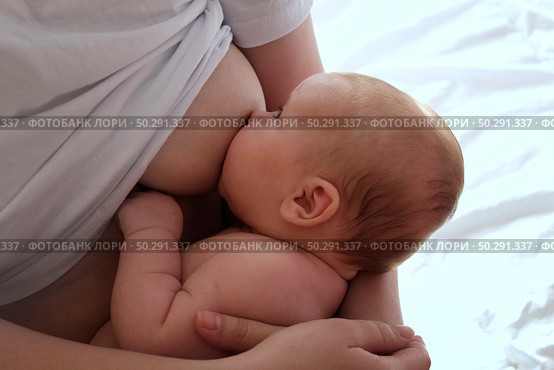 Mother breastfeeding baby at home. Mom nursing infant nurturing. Portrait of Child suckling milk from breast. Authentic shot of mother is breastfeeding her newborn baby. Close Up. Concept of maternity. Стоковое фото, фотограф Марина Демидюк / Фотобанк Лори