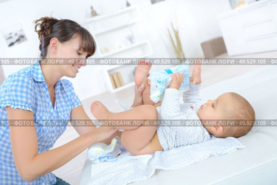 mother changing diapers of a nine months old baby. Стоковое фото, агентство Ingram Publishing / Фотобанк Лори