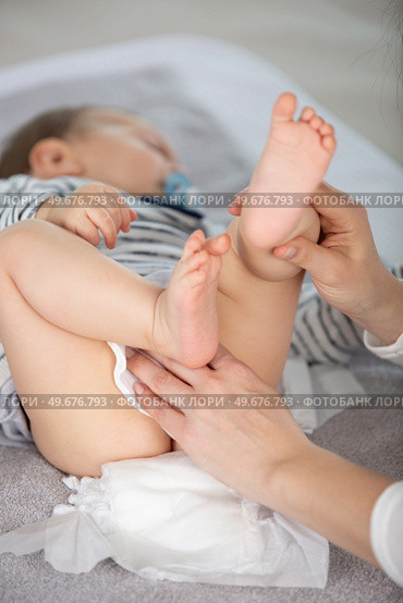 mother cleaning up her babys buttocks with wet hankies. Стоковое фото, агентство Ingram Publishing / Фотобанк Лори