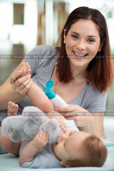mother putting diaper on her happy baby in nursery. Стоковое фото, агентство Ingram Publishing / Фотобанк Лори