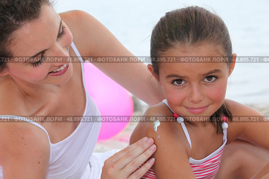Mother putting suncream on her daughter. Стоковое фото, агентство Ingram Publishing / Фотобанк Лори
