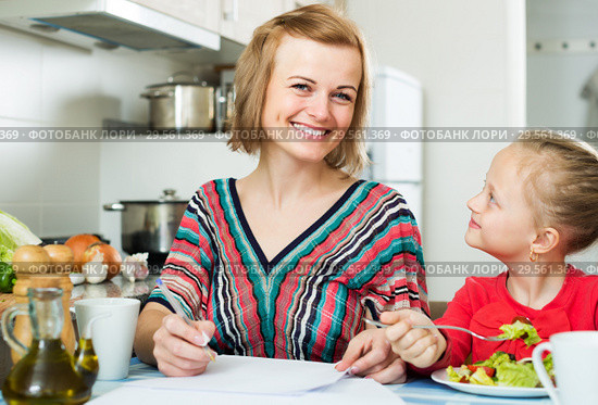 Mother working and girl eating. Стоковое фото, фотограф Яков Филимонов / Фотобанк Лори