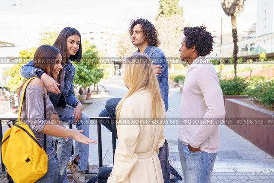 Multi-ethnic group of friends gathered in the street leaning on a railing. Young people having fun together.. Multi-ethnic group of friends gathered in the street leaning on a railing. Стоковое фото, агентство Ingram Publishing / Фотобанк Лори