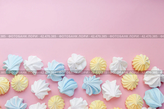 Multicolored meringue on a pink pastel background with copy space. Delicious dessert. Colorful handmade meringue. Стоковое фото, фотограф Александра Баранова / Фотобанк Лори