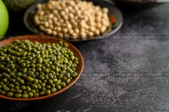 Mung bean and Soy bean on the plate on a black cement floor background. Стоковое фото, агентство Ingram Publishing / Фотобанк Лори