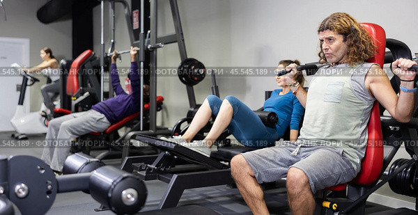 Muscular sports bodybuilder in gym is engaged in simulators. Стоковое фото, фотограф Яков Филимонов / Фотобанк Лори
