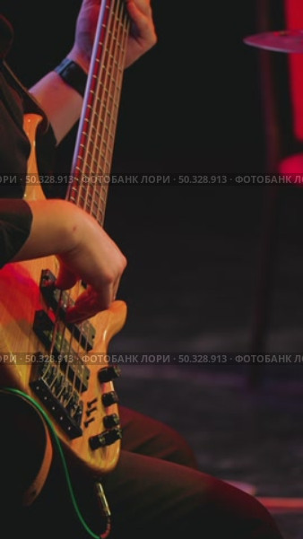 Musician playing bass guitar on stage. Close-up of five-stringed instrument and professional playing on it. Live concert. Стоковое видео, видеограф Воловодов Владимир / Фотобанк Лори