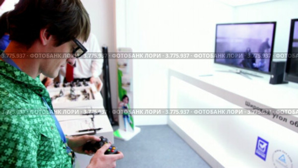 Мужчина играет в 3D видео игру на Конференции разработчиков игр 2011 (2012 год). Редакционное видео, видеограф Losevsky Pavel / Фотобанк Лори