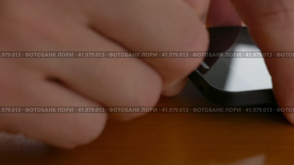 Мужчина отключает USB-кабель от смартфона. Стоковое видео, видеограф Садовский Анатолий / Фотобанк Лори