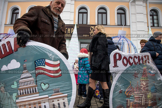 Мужчина выставляет баннеры с надписями "США" и "Россия" на Красной площади города Рыбинска, Россия (2017 год). Редакционное фото, фотограф Николай Винокуров / Фотобанк Лори