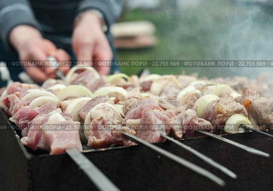 Мужчина жарит шашлык из мяса с луком на углях. Стоковое фото, фотограф Игорь Низов / Фотобанк Лори