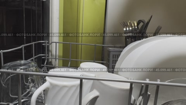 Мужская рука открывает дверцу посудомоечной машины и достает подносы с чистой посудой. Крупный план. Стоковое видео, видеограф Ярославский Максим / Фотобанк Лори