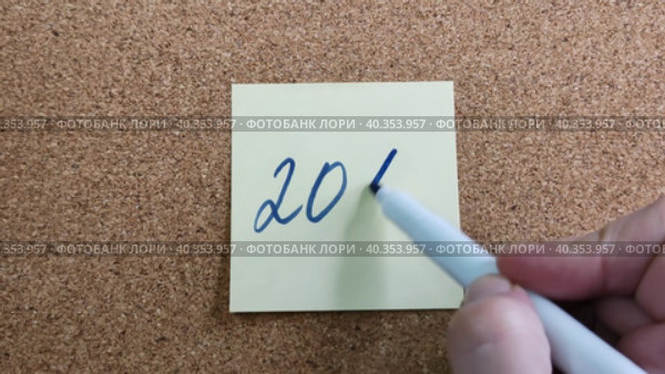 Надпись 20% на бумажном стикере приклеенном к пробковой  доске. Женщина пишет маркером на желтой бумаге. Синий фломастер в женской руке. Рукописный текст красивым почерком. Процент скидки или прибыли. The inscription is 20% on a paper sticker glued to a cork board. A woman writes with a marker on yellow paper. A blue felt-tip pen in a woman's hand. Handwritten text in a beautiful handwriting. Percentage of discount or profit. Стоковое видео, видеограф Ирина / Фотобанк Лори