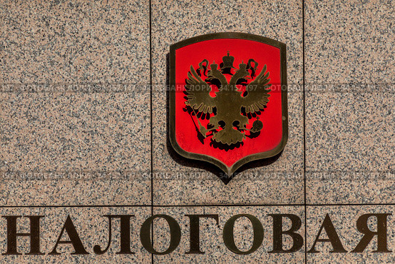 Надпись "Налоговая" и герб Российской Федерации на фасаде здания налоговой инспекции в городе Москве, Россия (2020 год). Редакционное фото, фотограф Николай Винокуров / Фотобанк Лори