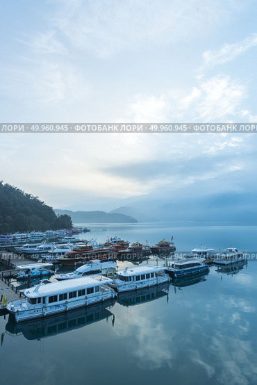 Nantou, Taiwan - November 02, 2016 : Tourist boats docking in peachful morning at Shuishe Pier, Sun Moon Lake, Taiwan. Редакционное фото, агентство Ingram Publishing / Фотобанк Лори