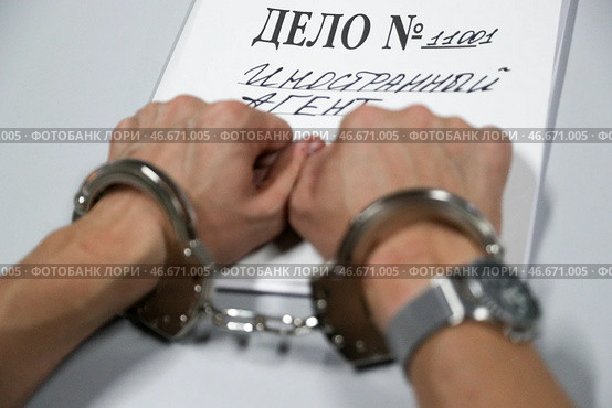 Наручники на арестованном преступнике и папка-скоросшиватель "Дело № 11001 Иностранный агент". Алексей Белкин/NEWS.ru/TACC. Стоковое фото, фотограф Белкин Алексей / ТАСС / Фотобанк Лори