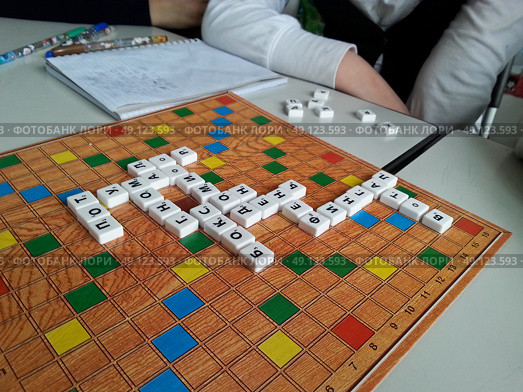 Настольная игра Словодел (Scrabble) лежит на столе (2015 год). Редакционное фото, фотограф Snezka / Фотобанк Лори