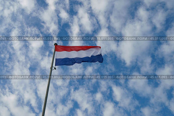 National flag of the Netherlands (blue, white and red stripes). Flags blowing on the wind in a sunny summer day. Flags against blue sky background. (2019 год). Стоковое фото, фотограф YuryKara / Фотобанк Лори