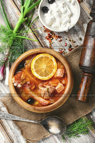 National Ukrainian soup Solyanka. Traditional solyanka with smoked meats in wooden plate. Стоковое фото, агентство Ingram Publishing / Фотобанк Лори