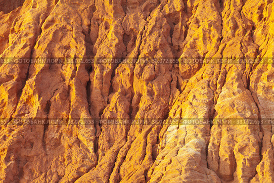 Natural background of erosion of clay sandstone rocks under the influence of sea wind and precipitation. Natural phenomena. Bright texture of decaying soil. Стоковое фото, фотограф Виктория Катьянова / Фотобанк Лори