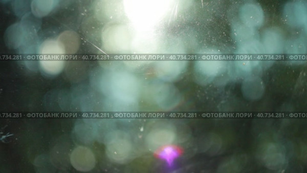 Natural blurry bokeh motion background with some artifacts like scratches on the foreground glass. Стоковое видео, видеограф Евгений Тарасенко / Фотобанк Лори