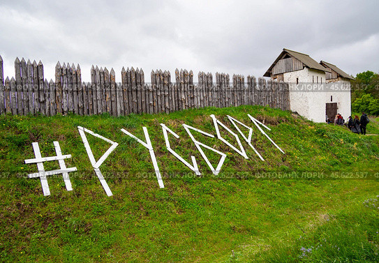 Название фестиваля исторической реконструкции "Русборг" выложено досками перед частоколом крепости (2024 год). Редакционное фото, фотограф Вячеслав Палес / Фотобанк Лори
