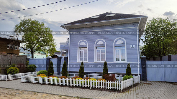 Neat, stylish wooden house at 9 Burmakinykh Street. Blue one-story house with well-kept front garden with flowers and thuja trees. Russia, Vologda, May 23, 2025. Аккуратный стильный деревянный дом по адресу улица Бурмагиных, 9. Голубой одноэтажный домик с ухоженным палисадником с цветами и туями. Россия, Вологда, 23 мая 2025. Редакционное фото, фотограф Ирина / Фотобанк Лори