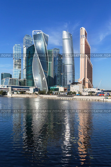 Небоскребы  Москва-сити с отражением в воде. Вертикальный формат. Moscow-city (Moscow International Business Center). Summer. Sunny day. (2016 год). Редакционное фото, фотограф Лариса Гордеева / Фотобанк Лори