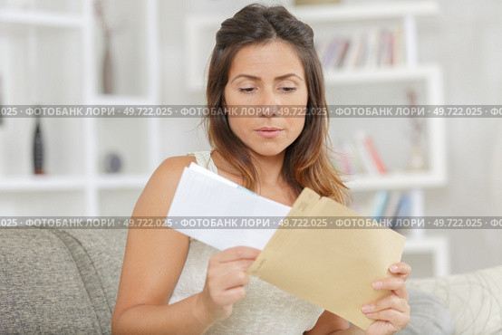 nervous woman taking letter from envelope. Стоковое фото, агентство Ingram Publishing / Фотобанк Лори