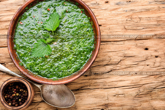 Nettle soup in bowl on wooden surface.Green nettle soup. Russian traditional nettle soup. Стоковое фото, агентство Ingram Publishing / Фотобанк Лори