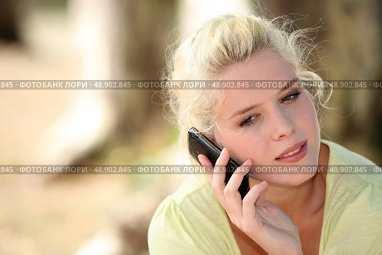 Neutral woman talking on her mobile phone. Стоковое фото, агентство Ingram Publishing / Фотобанк Лори