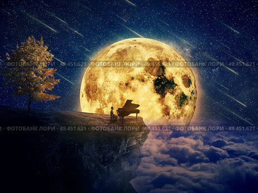 Night scene with a boy, musician standing at the edge of a cliff chasm with his piano. Waiting for music inspiration in the center of nature, over a full moon night background. Стоковое фото, агентство Ingram Publishing / Фотобанк Лори
