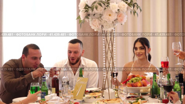 Nizhny Novgorod, Russia Kazan highway 29, 08.10.2023. Wedding. People are sitting at a round festive table with white tablecloths, eating delicious food and drinking wine. Нижний Новгород, Россия, Казанское шоссе, 29, 08.10.2023. Свадьба. Люди сидят за круглым праздничным столом, накрытым белыми скатертями, едят вкусную еду и пьют вино. Редакционное видео, видеограф Egor Sarantstv / Фотобанк Лори