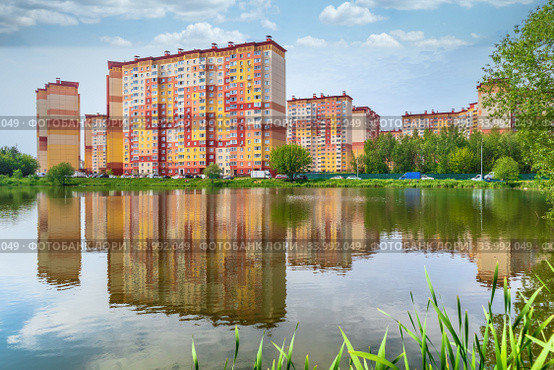 Новостройки в Подмосковье. Новый жилой район «Новые Островцы» отражается в воде озера Баулино. Россия, Раменский район (2020 год). Стоковое фото, фотограф Владимир Сергеев / Фотобанк Лори