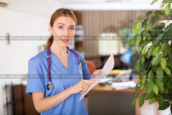 Nurse standing in hall with clipboard in hands. Стоковое фото, фотограф Яков Филимонов / Фотобанк Лори