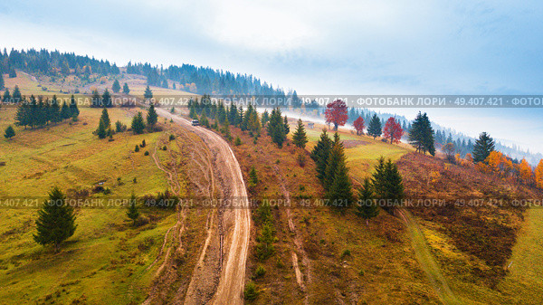 Off-road car climbing on a mountain extreme rural dirt road. Muddy hillside in autumn rainy season. Стоковое фото, агентство Ingram Publishing / Фотобанк Лори