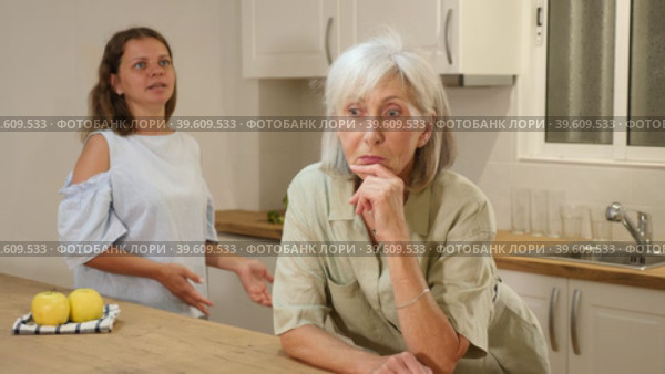 Offended senior woman at kitchen and listening her daughter swearing. Стоковое видео, видеограф Яков Филимонов / Фотобанк Лори