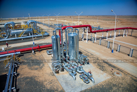 Oil refinery plant in desert sand. Panorama. Red pipes, heat exchanger, other metal equipment and red valves. Стоковое фото, фотограф Alexey Rezvykh / Фотобанк Лори