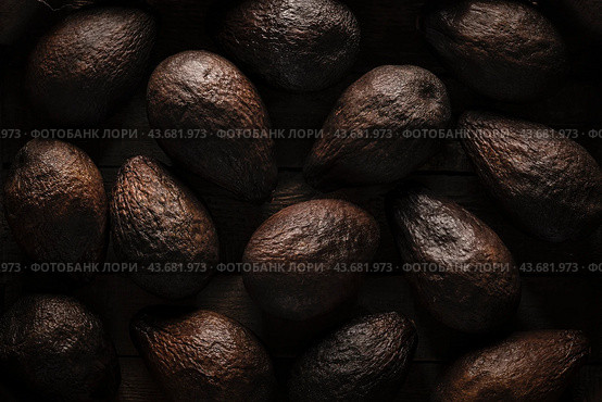 Old blackened spoiled brown avocados in - Beautiful dark black textured background, top view. Стоковое фото, фотограф Владимир Разгуляев / Фотобанк Лори