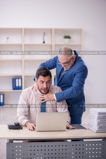 Old male boss and young male employee in bullying concept. Стоковое фото, фотограф Elnur / Фотобанк Лори
